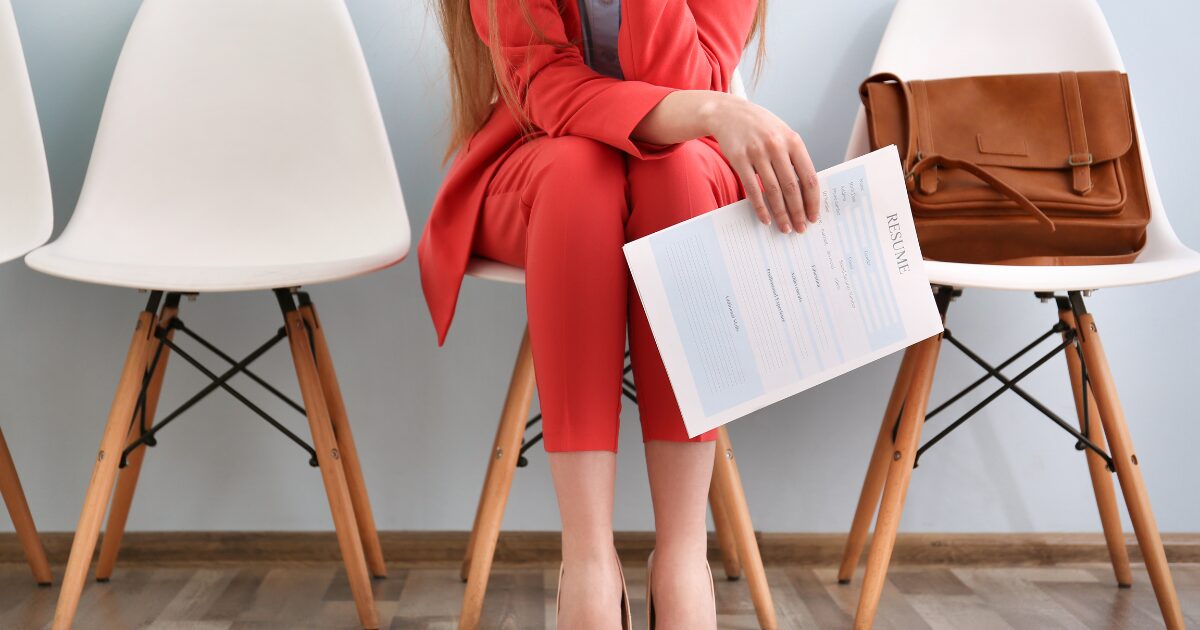 woman holding resume waiting to be interviewed for a job that would move her forward on her career path.